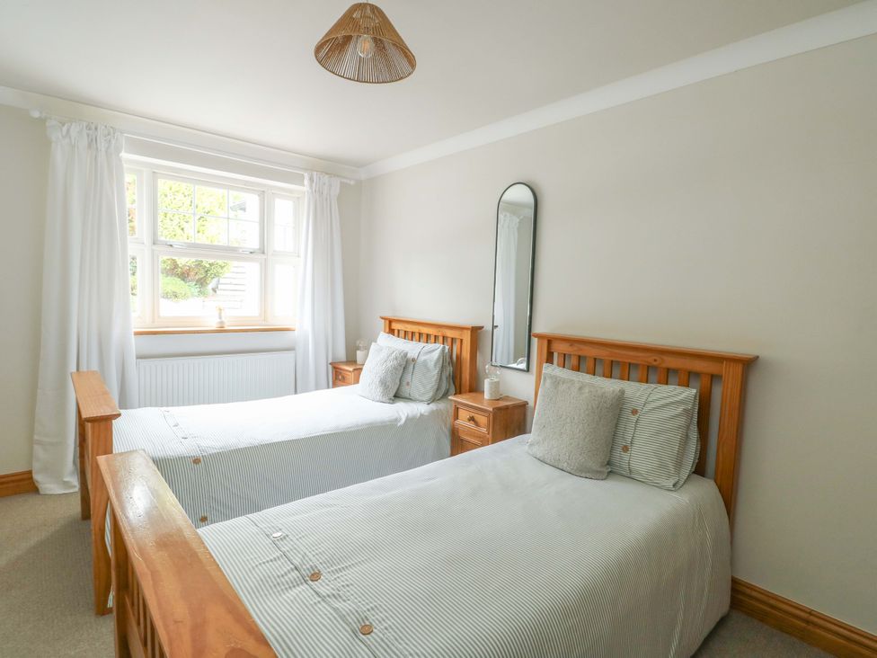A bedroom with two beds and a window at Bwthyn Clai in Llangefni