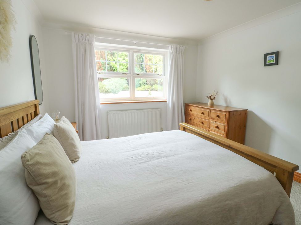 A bedroom with a bed and dresser at Bwthyn Clai in Llangefni