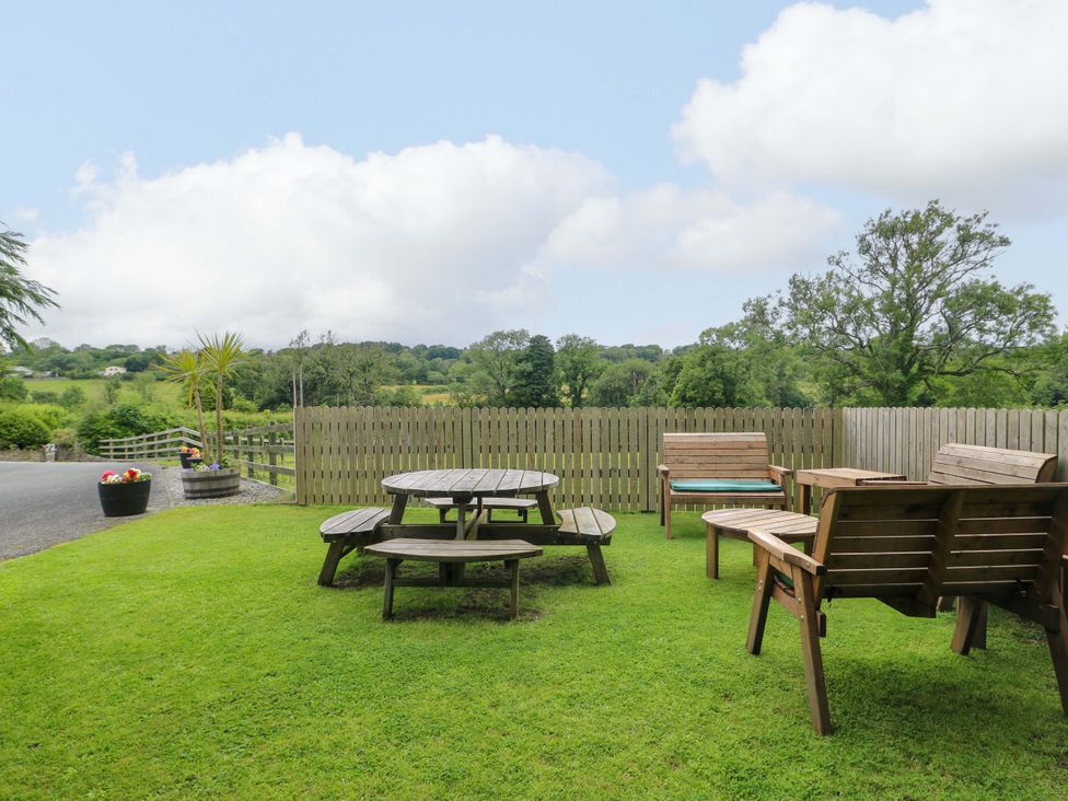 A garden with a table and chairs at Bwthyn Clai in Llangefni