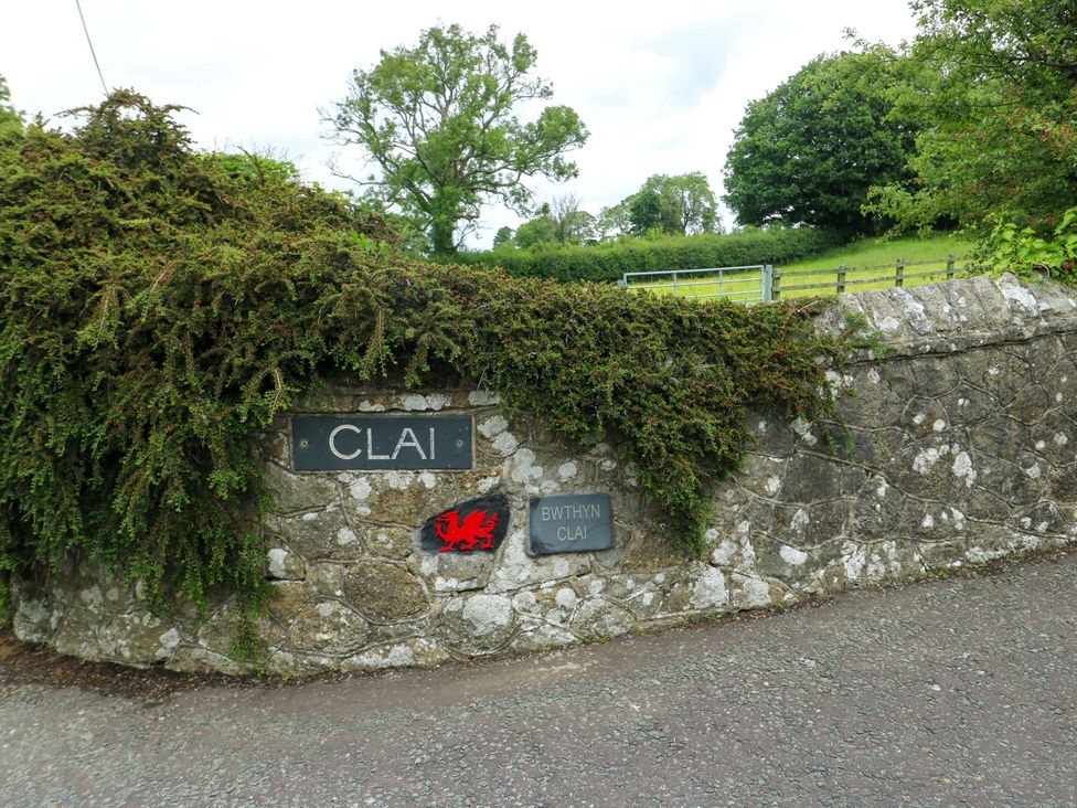 A stone wall with signs for Claai and Bwthyn Clai at Bwthyn Clai in Llangefni