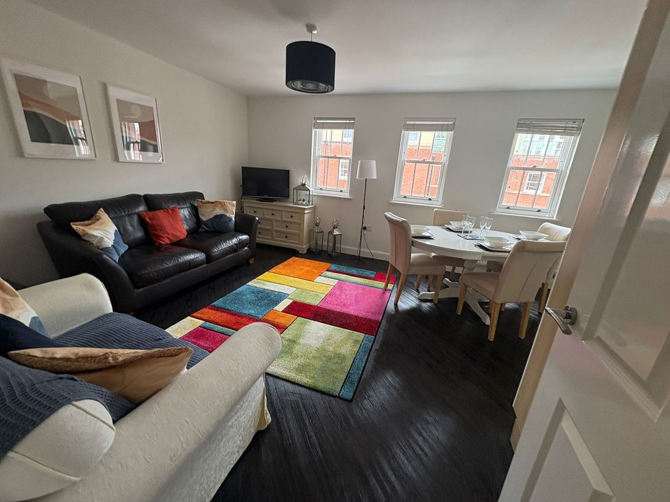 A living room with a sofa and dining table at 122 The Old Meadow in Shrewsbury