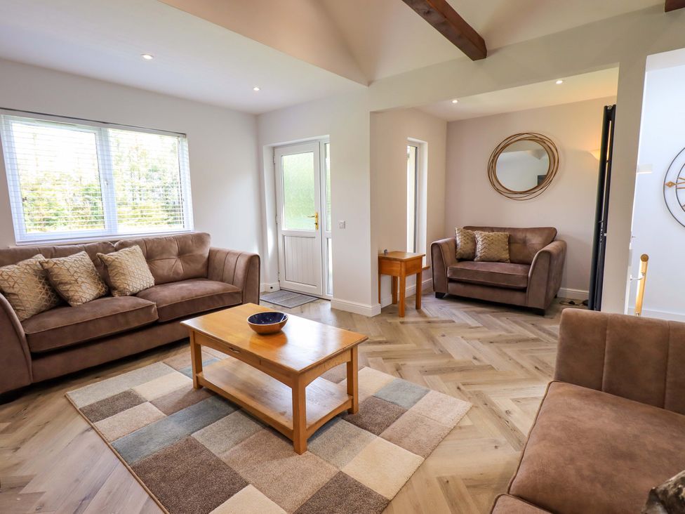 A living room with sofas and a table at Mallard Cottage in Penrith