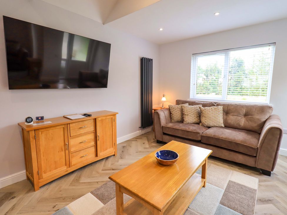 A living room with a sofa, coffee table and television at Mallard Cottage, Penrith