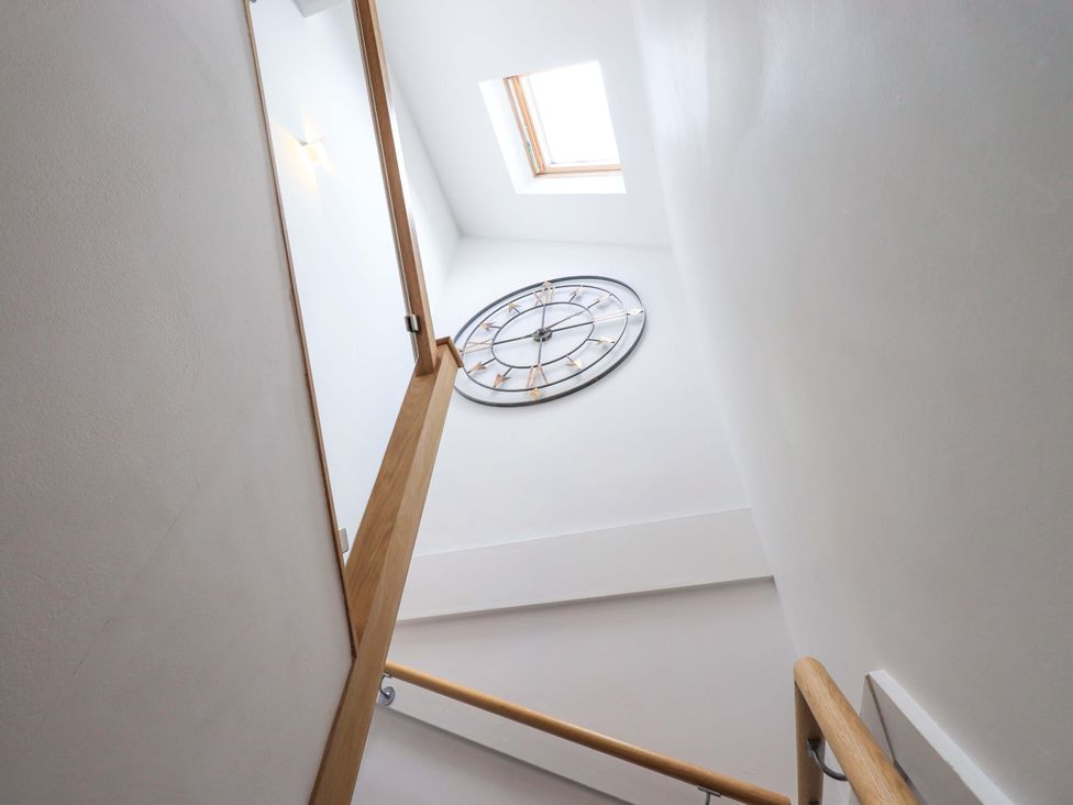 A staircase with a clock and skylight at Mallard Cottage Penrith