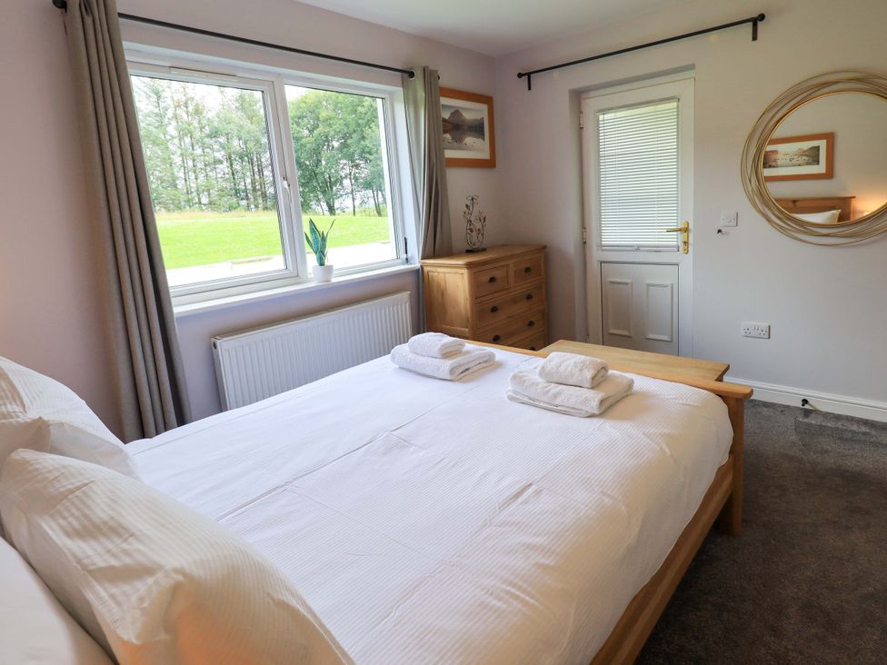 A bedroom with a bed and dresser at Mallard Cottage in Penrith