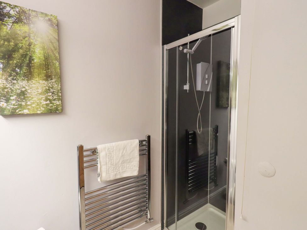 A bathroom with a shower and towel radiator at Mallard Cottage Penrith