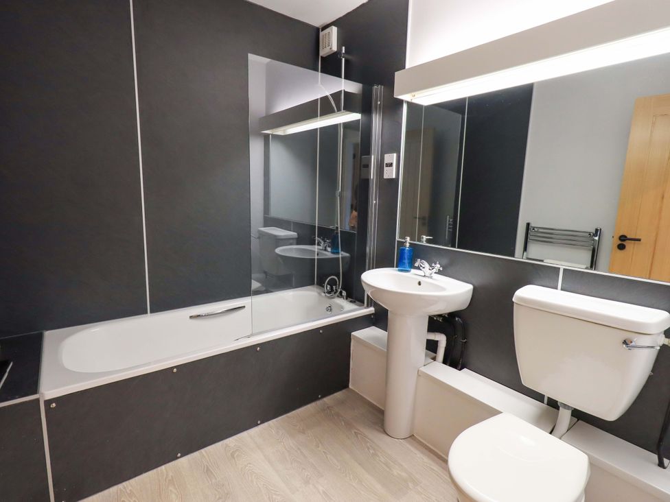 A bathroom with a bathtub, sink, and toilet at Mallard Cottage in Penrith