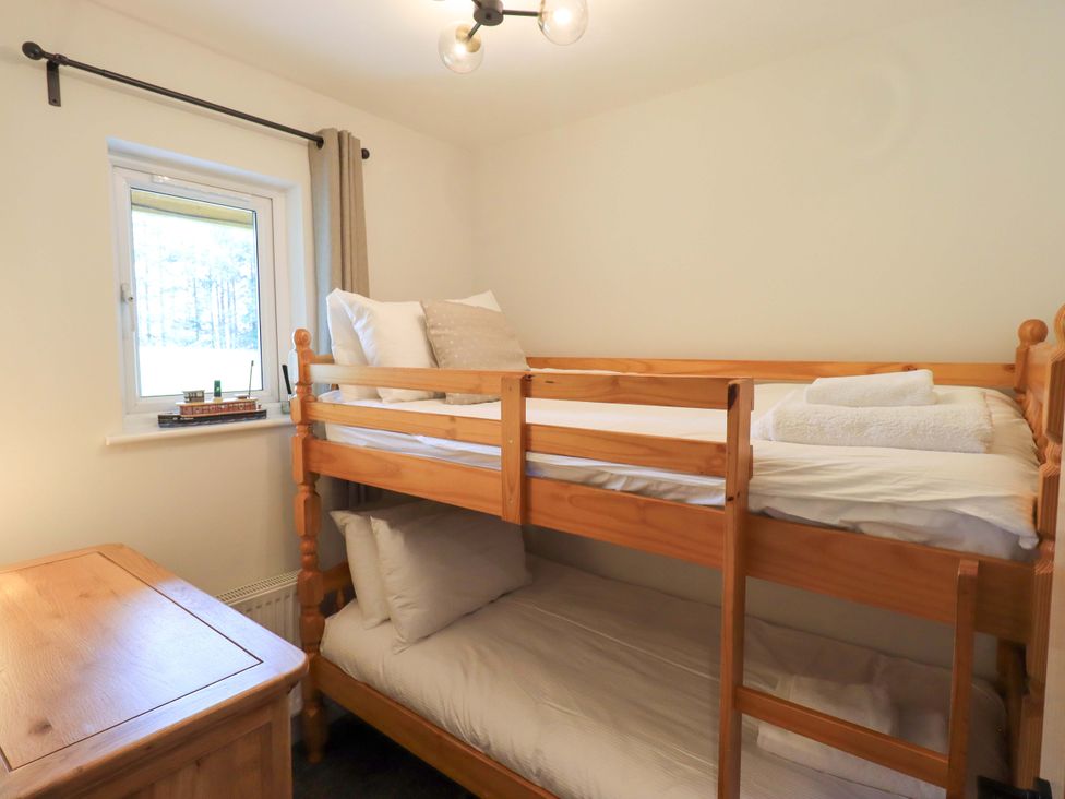 A bedroom with a bunk bed and window at Mallard Cottage in Penrith