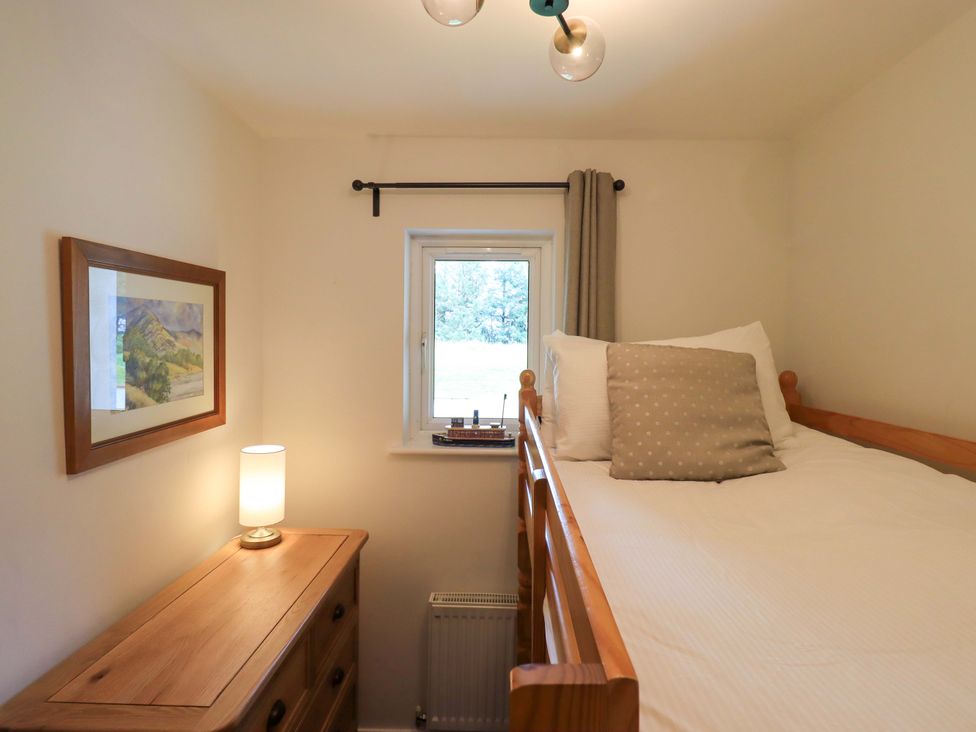 A bedroom with a bed and lamp at Mallard Cottage in Penrith