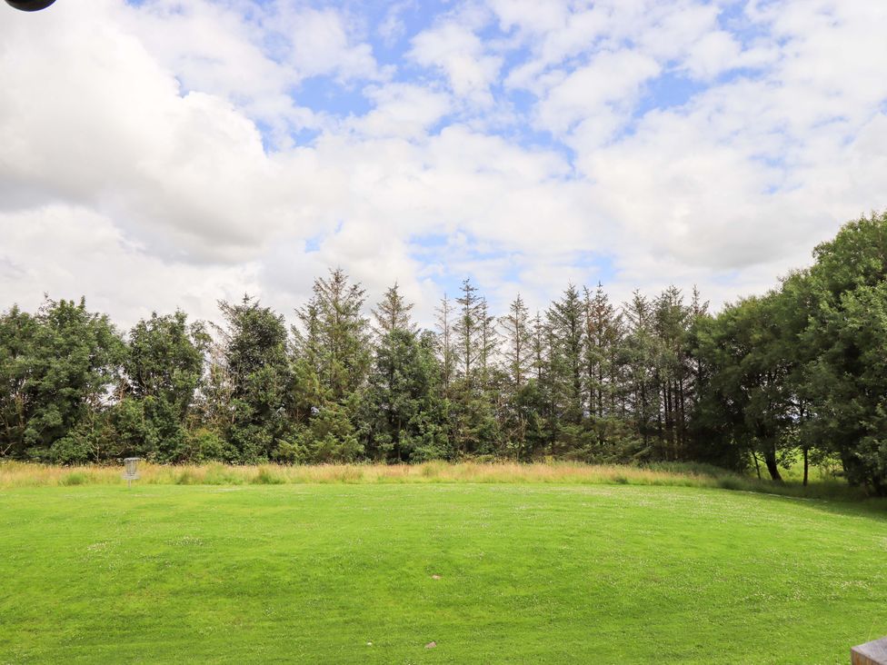 A field with grass and trees under a cloudy sky at Mallard Cottage Penrith