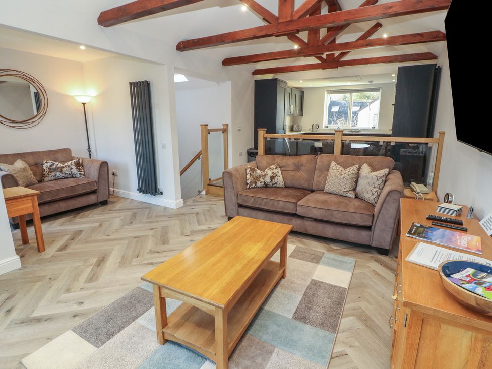 A living room with seating arrangements and a coffee table at Mallard Cottage in Penrith