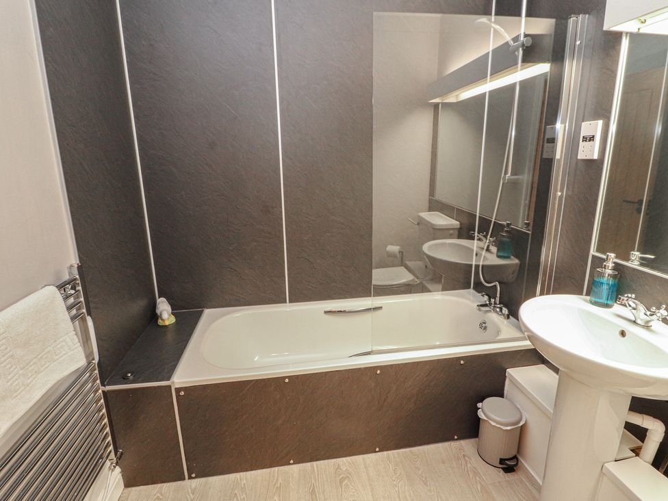 A bathroom with a bathtub, sink, and toilet at Mallard Cottage in Penrith