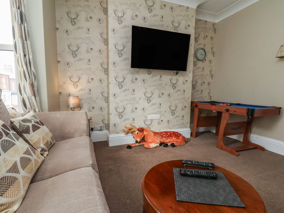 A living room with a sofa and game table at 35 Moorland Road in Scarborough