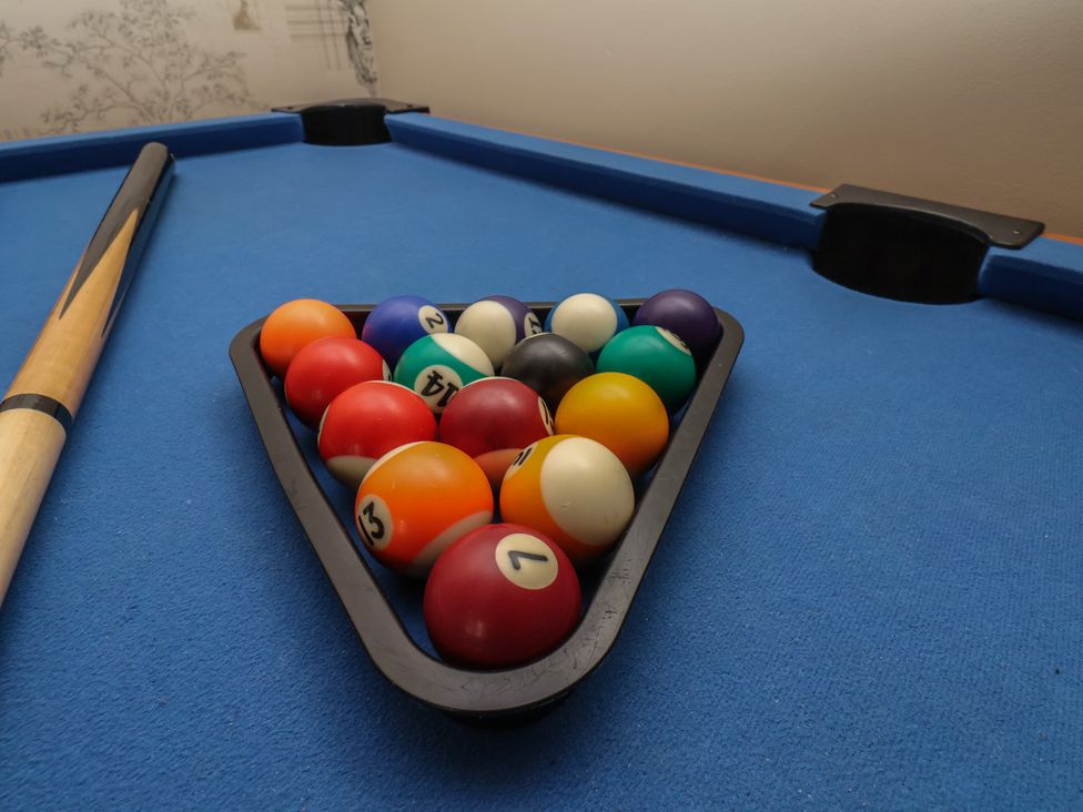 A pool table with balls and a cue stick at 35 Moorland Road Scarborough