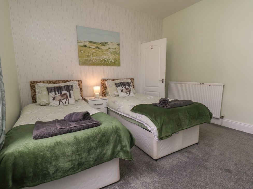 A bedroom with two single beds and a bedside table at 35 Moorland Road Scarborough