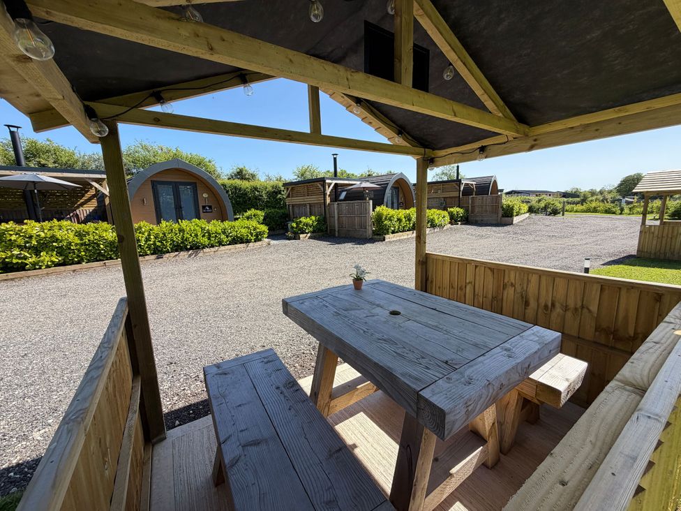 An outdoor seating area with a table and benches at No Deer in Ashbourne