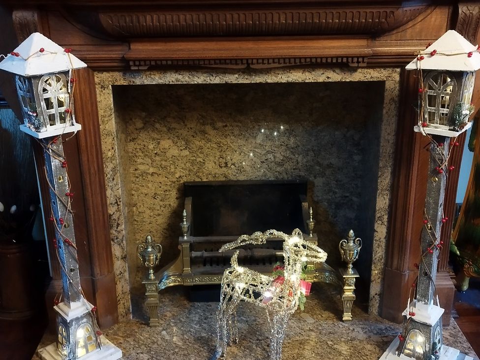 A fireplace with decorative deer and candlestick holders at Highcliffe Manor in Flamborough