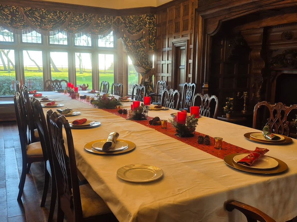 A dining room with a long table set for a meal at Highcliffe Manor in Flamborough