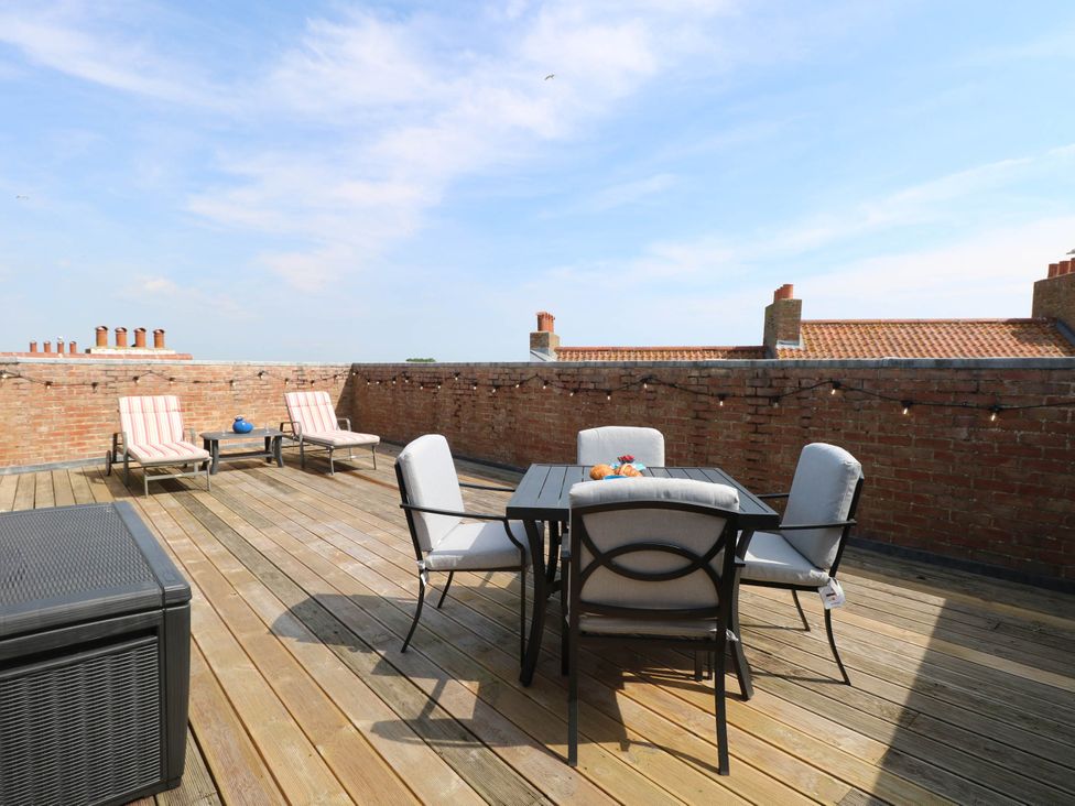 An outdoor terrace with seating and a table at Skylark Southwold