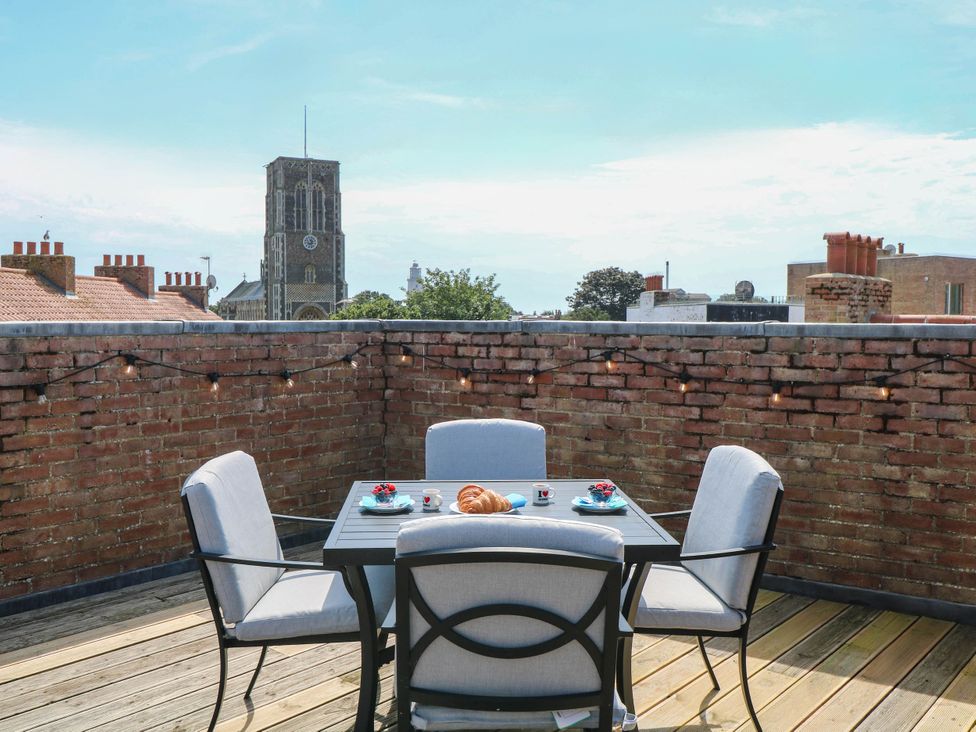 A rooftop terrace with a table and chairs at Skylark in Southwold