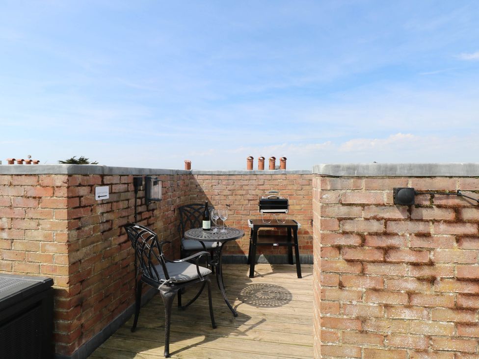 A terrace with a table and chairs at Skylark in Southwold