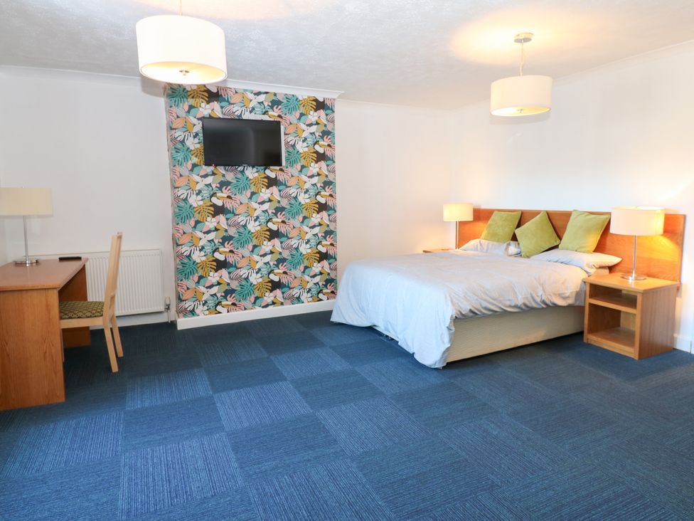 A bedroom with a bed and desk at Bedroom 1