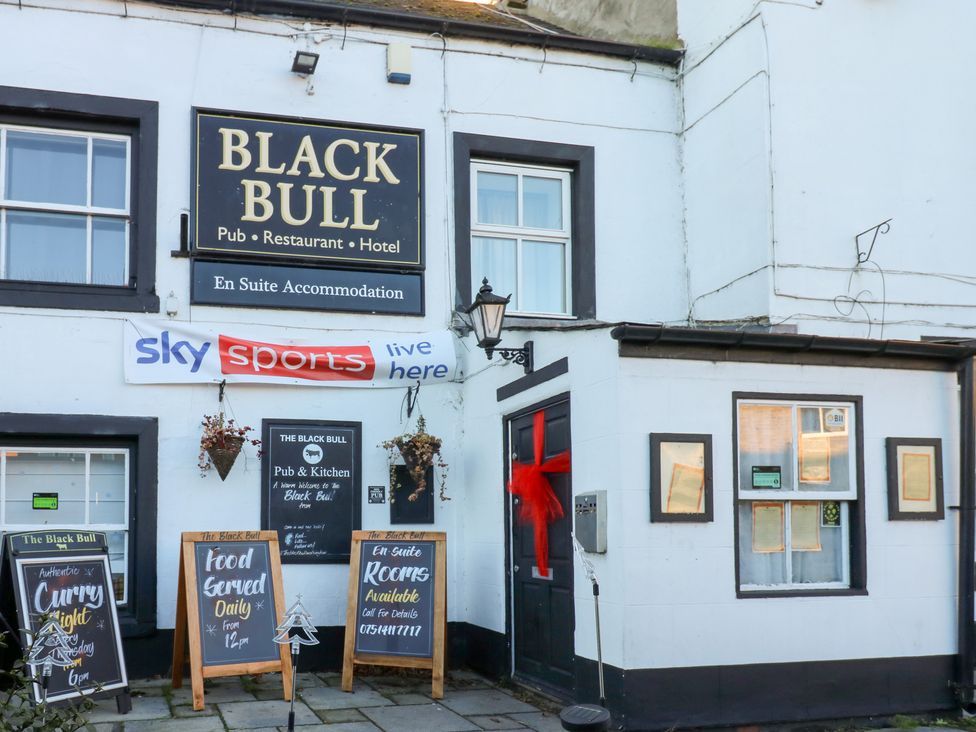 An exterior view of the Black Bull pub and restaurant with signage in 