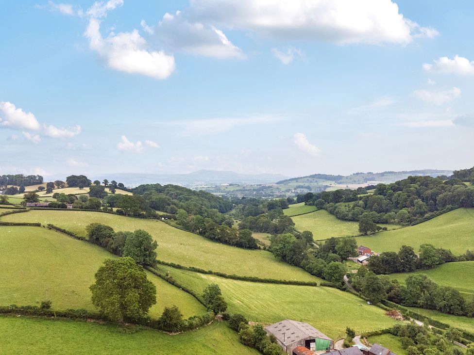 A countryside view with fields and hills at Barcud Coch - Red Kite in Garthmyl