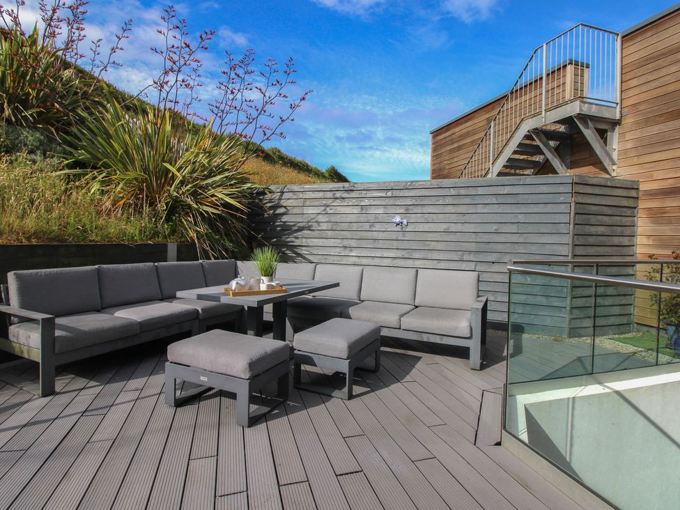 An outdoor seating area with a sofa and coffee table at 7 Beachdown in Challaborough