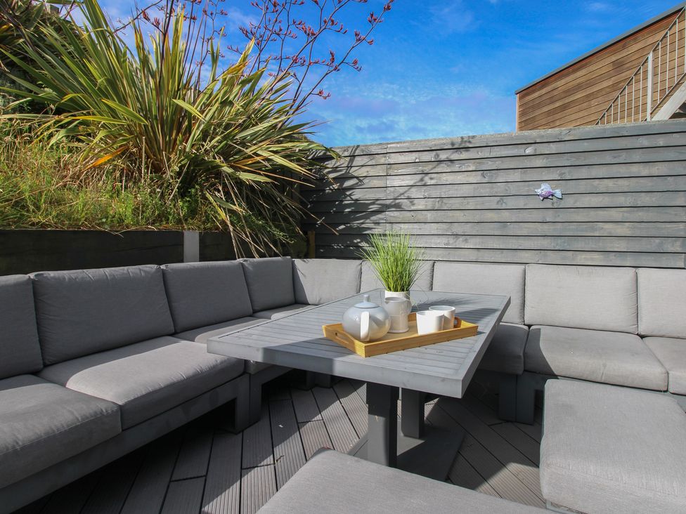 An outdoor space with a sectional sofa and table at 7 Beachdown, Challaborough