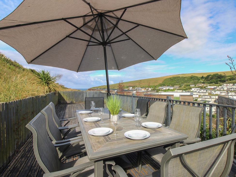 An outdoor dining area with a table and chairs at 7 Beachdown in Challaborough