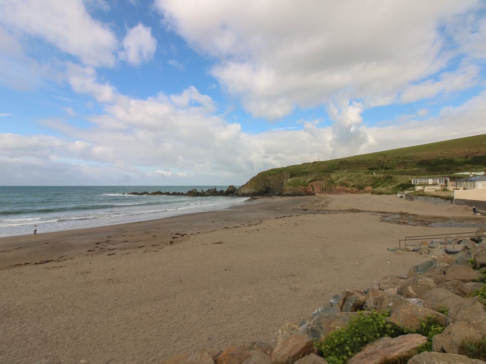 A beach with ocean and hills at 7 Beachdown Challaborough