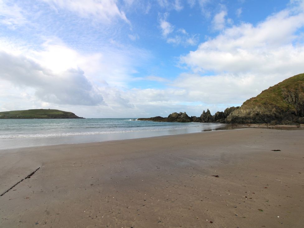 A beach with water and hills at 7 Beachdown, Challaborough