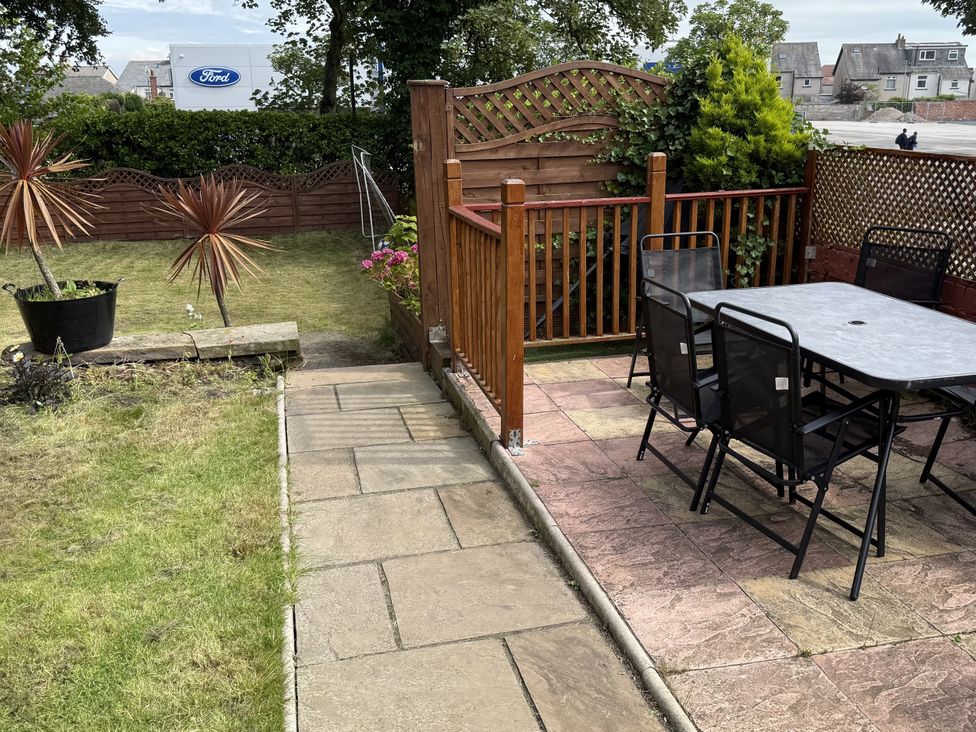 A garden with a table and chairs at The Furness Haven in Barrow-In-Furness