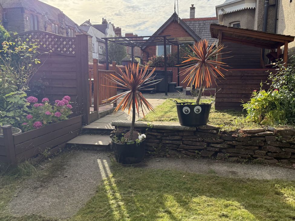 A garden with flower bed, paving stones, and plants at The Furness Haven in Barrow-In-Furness