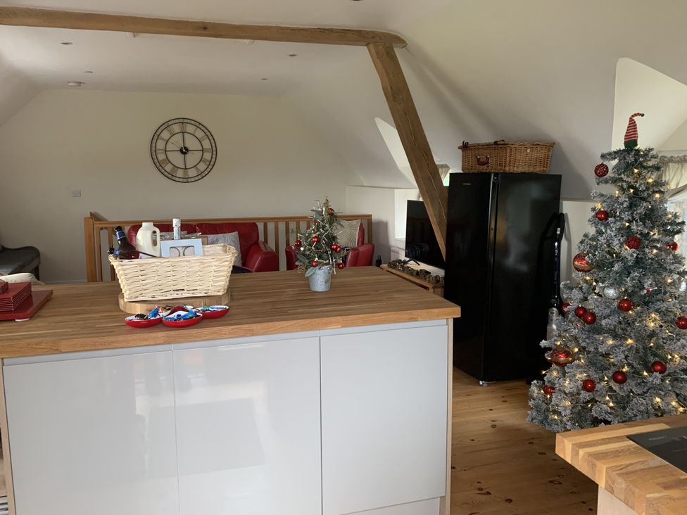 A kitchen with a refrigerator and a Christmas tree at Coach House, Clawdd-Newydd