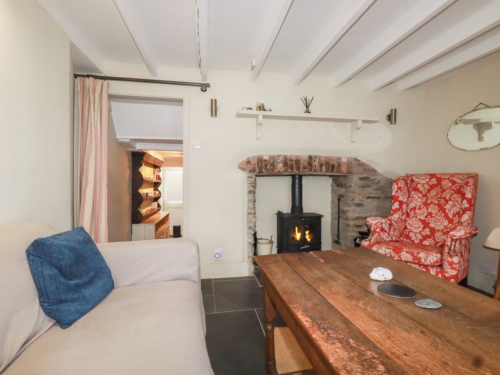 A living room with a fireplace and seating area at Penvar in Truro