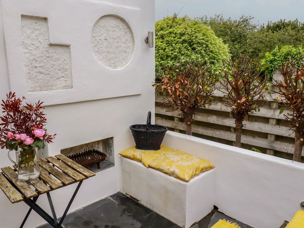 An outdoor seating area with a table and flowers at Penvar in Gerrans near Portscatho