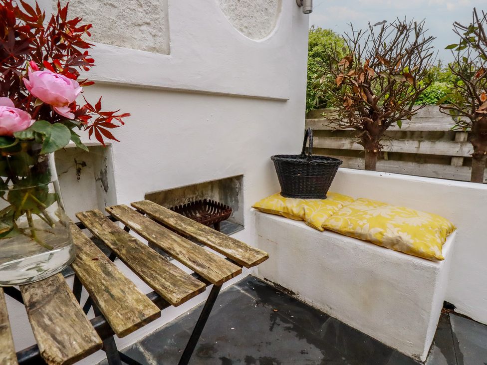 An outdoor seating area with a table and chair at Penvar in Gerrans near Portscatho