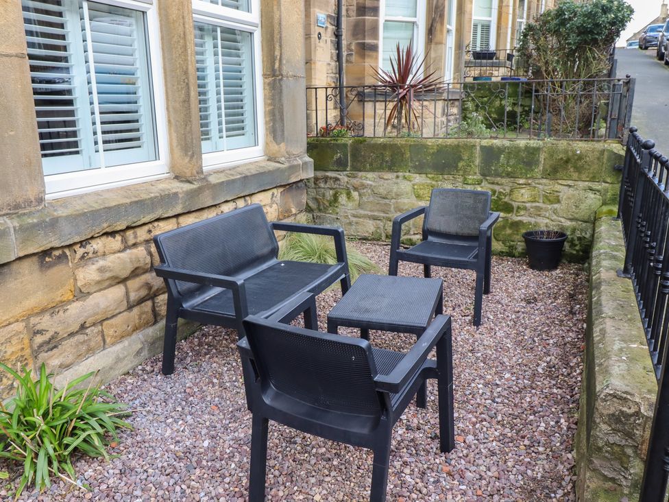 An outdoor seating area with black chairs and a table at Rose House in Alnmouth