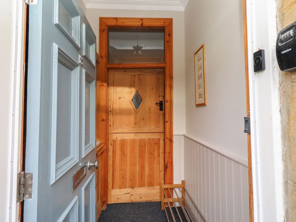 A hallway with a front door and internal door at Rose House Alnmouth
