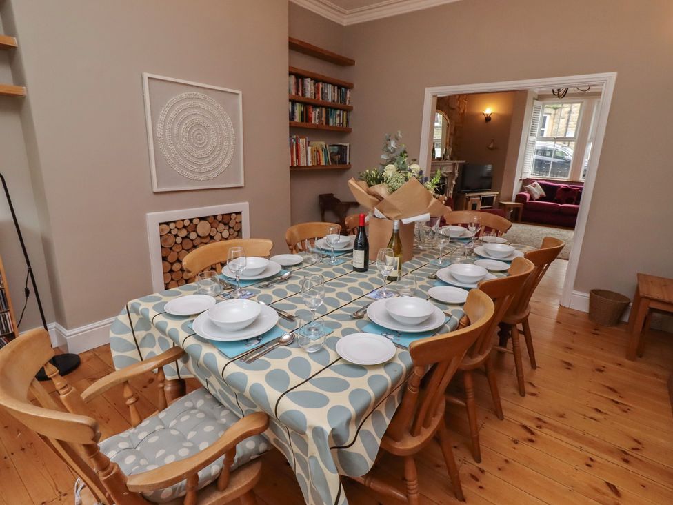 A dining room with a table set for meals at Rose House in Alnmouth
