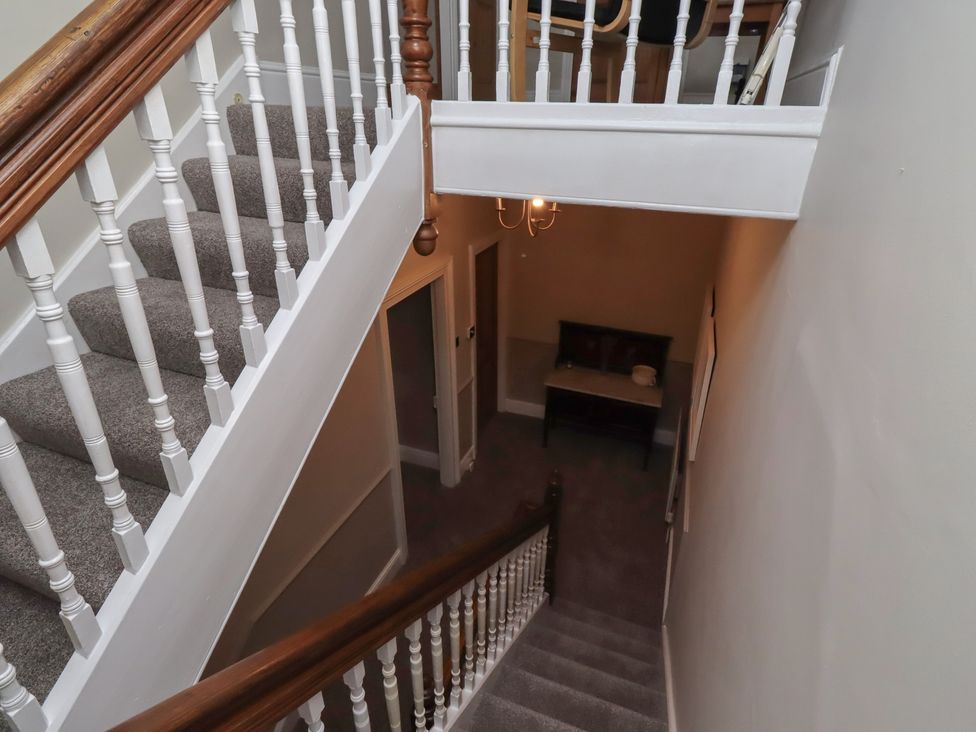 A staircase with a landing and a table at Rose House in Alnmouth