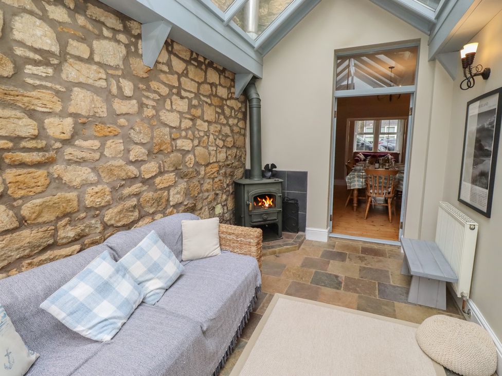 A snug with a fireplace and sofa at Rose House in Alnmouth