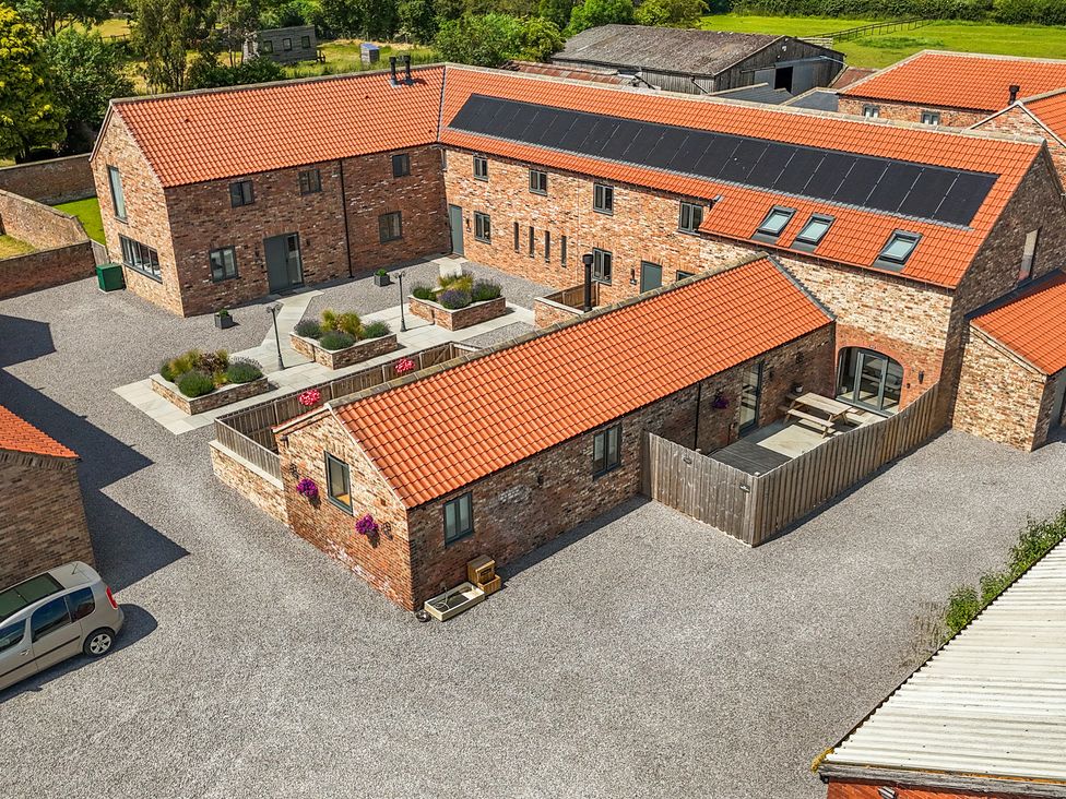 An outdoor area with several houses and a gravel driveway at The Mill House in Thirsk