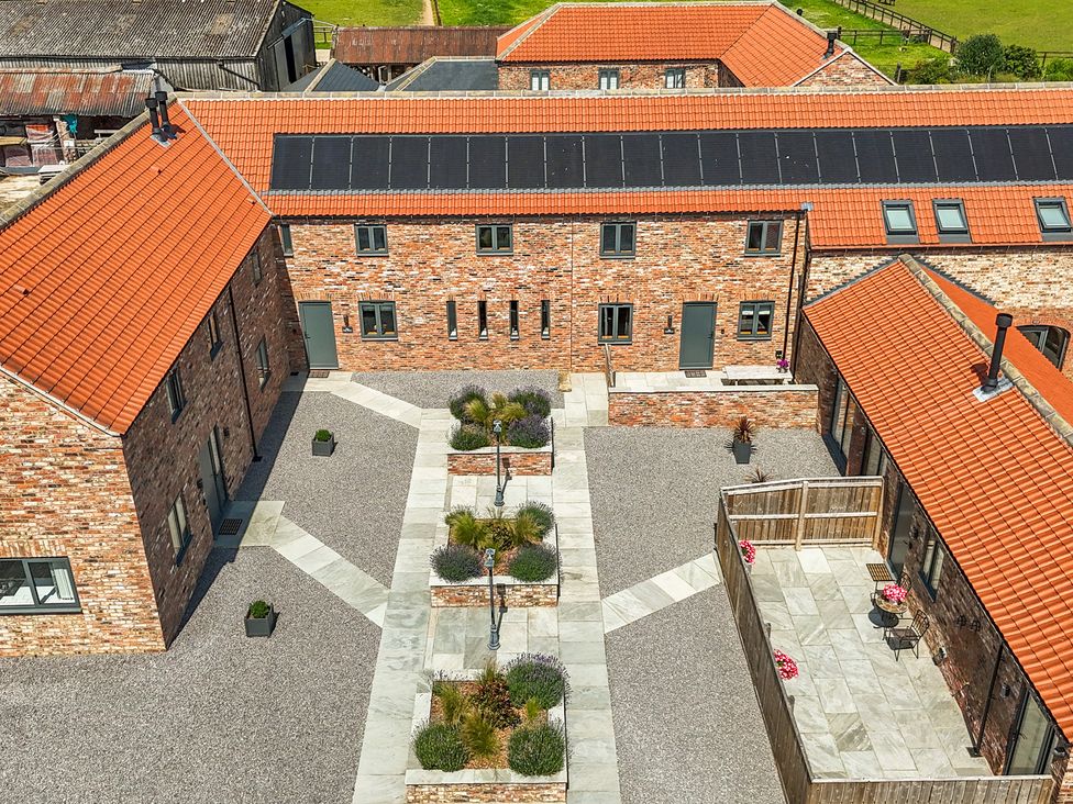 An outdoor courtyard with buildings and planters at The Mill House in Thirsk