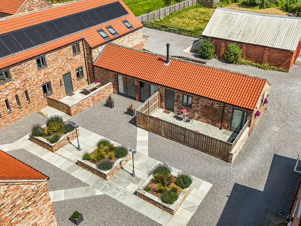 A courtyard with buildings and garden features at The Stables in Thirsk