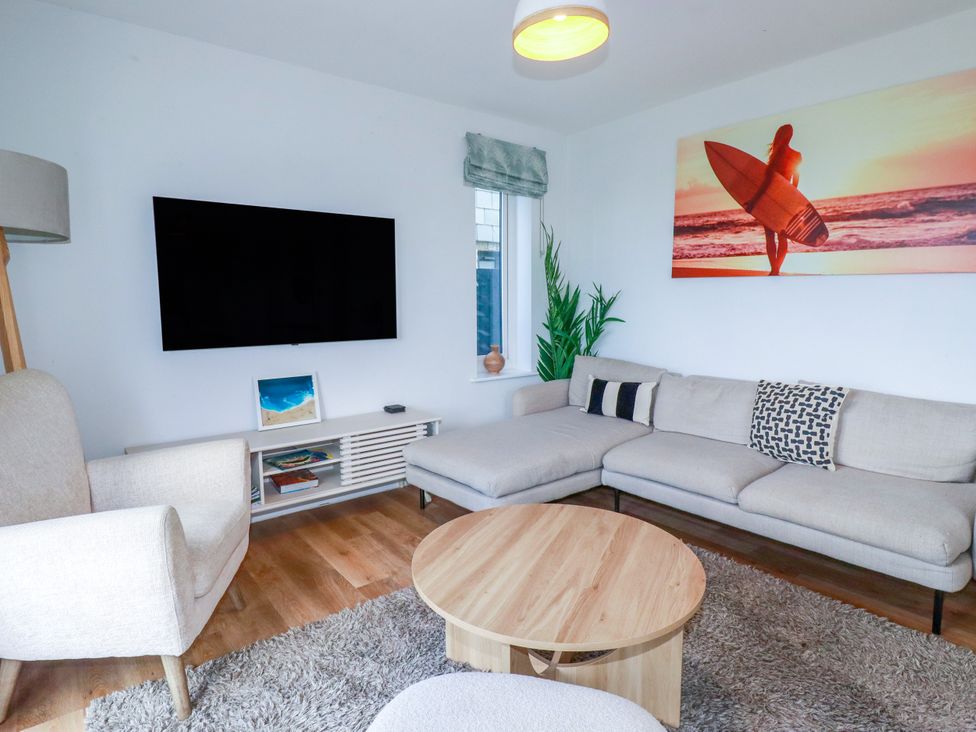 A living room with a television and sofa at Lavender House in Crantock