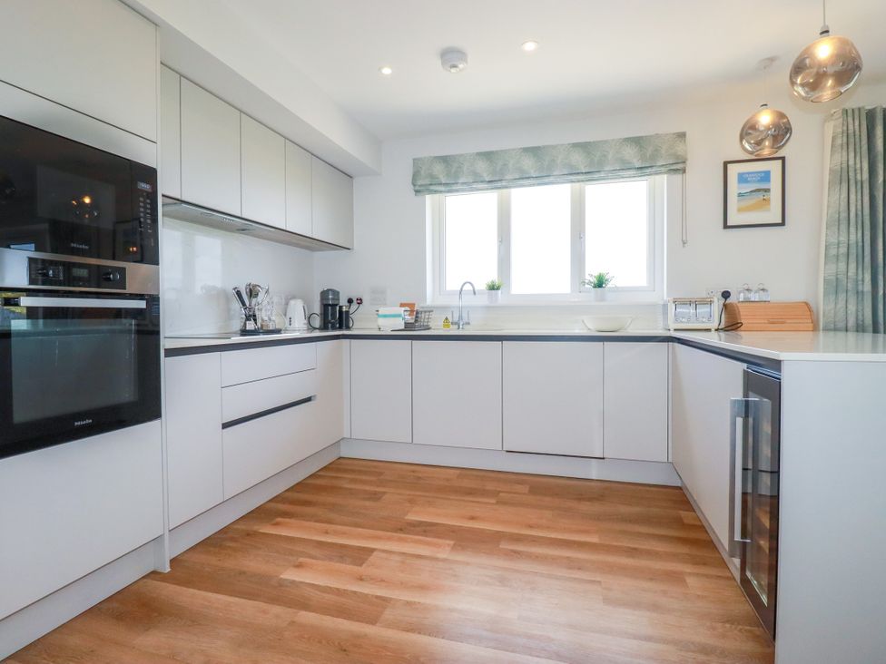 A kitchen with cabinets and appliances at Lavender House in Crantock