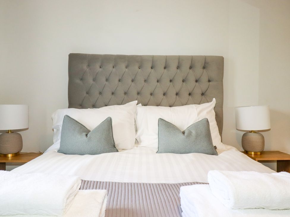 A bedroom with a bed and lamps at Lavender House in Crantock